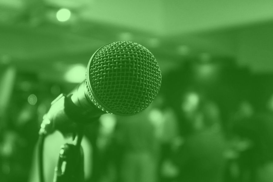 In gruen getauchtes Bild eines Mikrofons als Symbol fuer News Veranstaltungen, picture of a microphone in green as a symbol for news events